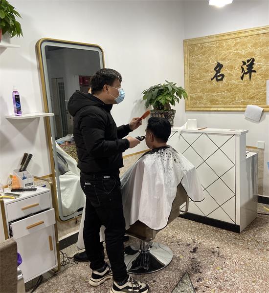 五星村龙廻塘小区名洋理发店正在给预约的客户理发
