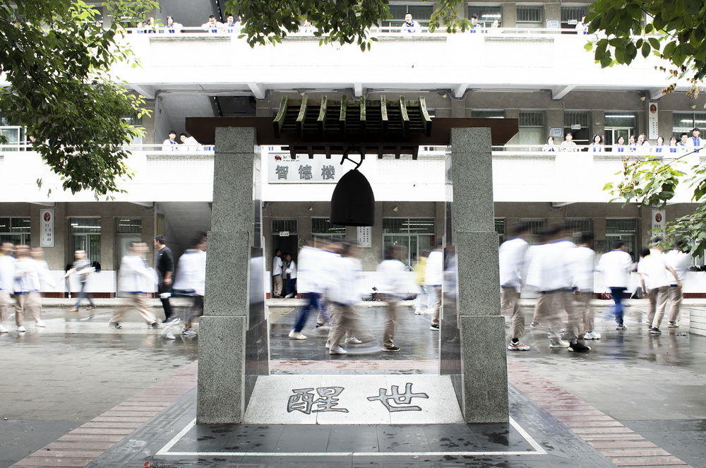 9月17日,四川省阆中中学国基广场,师生从"醒世钟"旁走过.