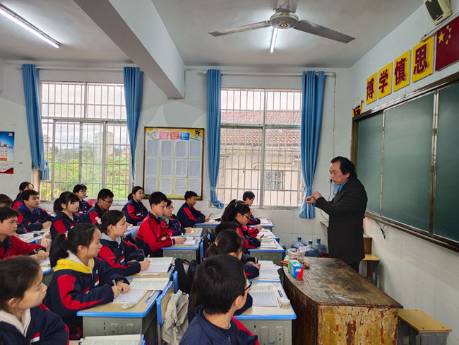 沅陵县书法家协会主席卢光淼在沅陵三中指导学生如何写字.