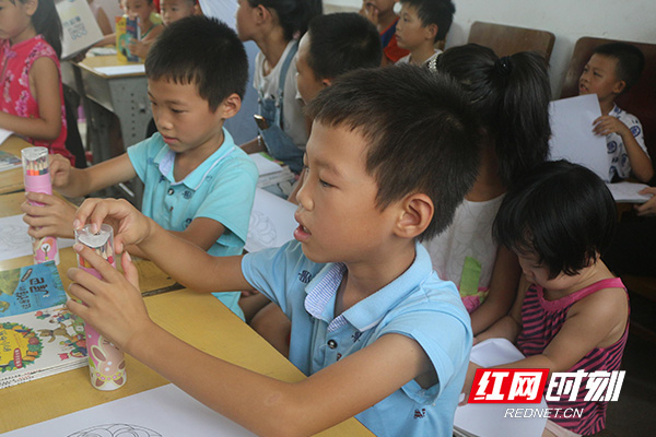 双胞胎蒋子豪、蒋子杰跟老师学习用彩色铅笔画图。.jpg