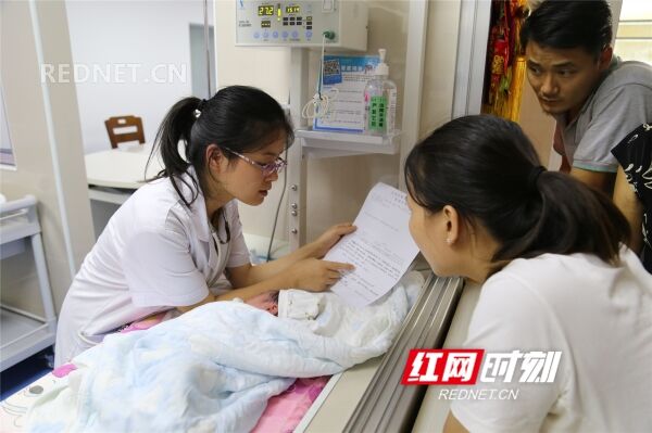 “要禁食2个小时，然后试着喂些奶水……”在新生儿科，29岁的医师义甜（左一）轻声细语，耐心的给患儿家属嘱咐注意事项。