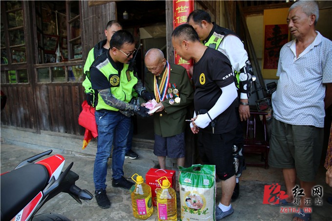 由24名摩托车爱好者组成的爱心车队来到桃江县武潭镇石桥村看望该村