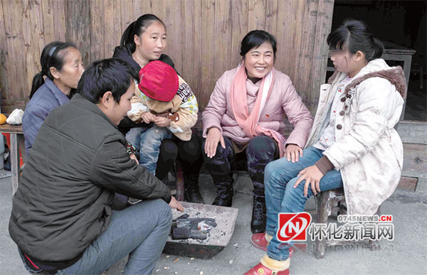 张小菊（右二）与帮扶贫困户李培银一家在一起。（米成善 摄）