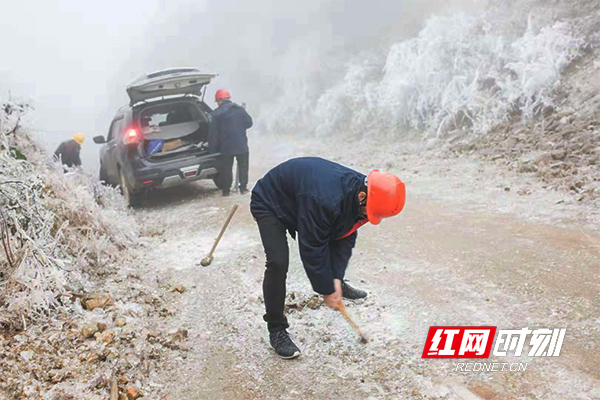 电力工人凿开山路冰层。1.jpg
