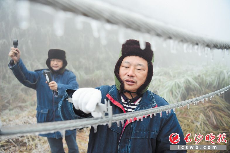 　　电力工人正在寒风中监测冰的厚度和风力大小。长沙晚报通讯员 彭红霞 摄