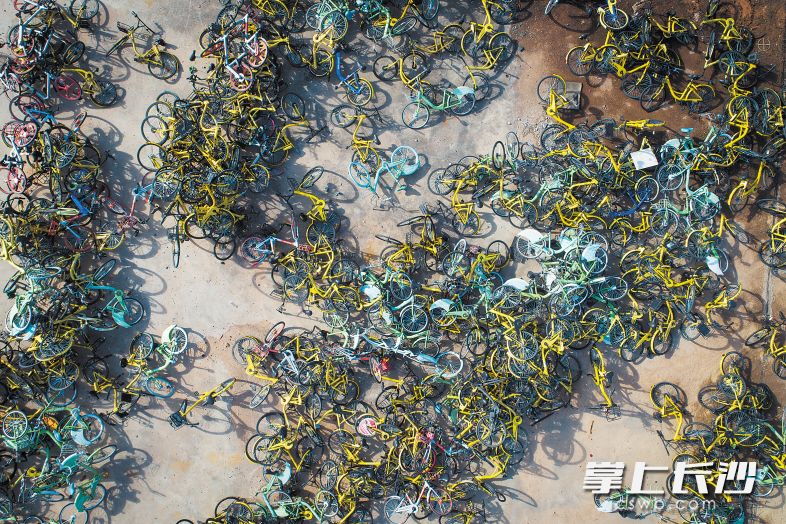 　　万明路松雅湖隧道上方的空地上堆放着数千辆共享单车，俯瞰令人触目惊心。　　长沙晚报记者 黄启晴 摄