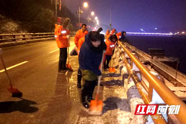 市政局晚班值守人员在殷家冲高架桥路面铲冰除雪。.jpg