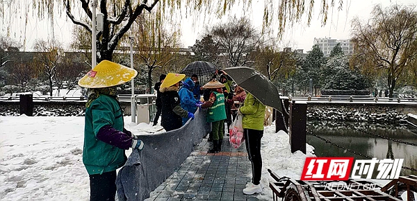 齐白石公园的工作人员为铺路的城管人送上温暖的姜茶.jpg