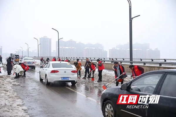 邵东县环卫局干部职工在金龙桥地段铲雪。（刘海摄）