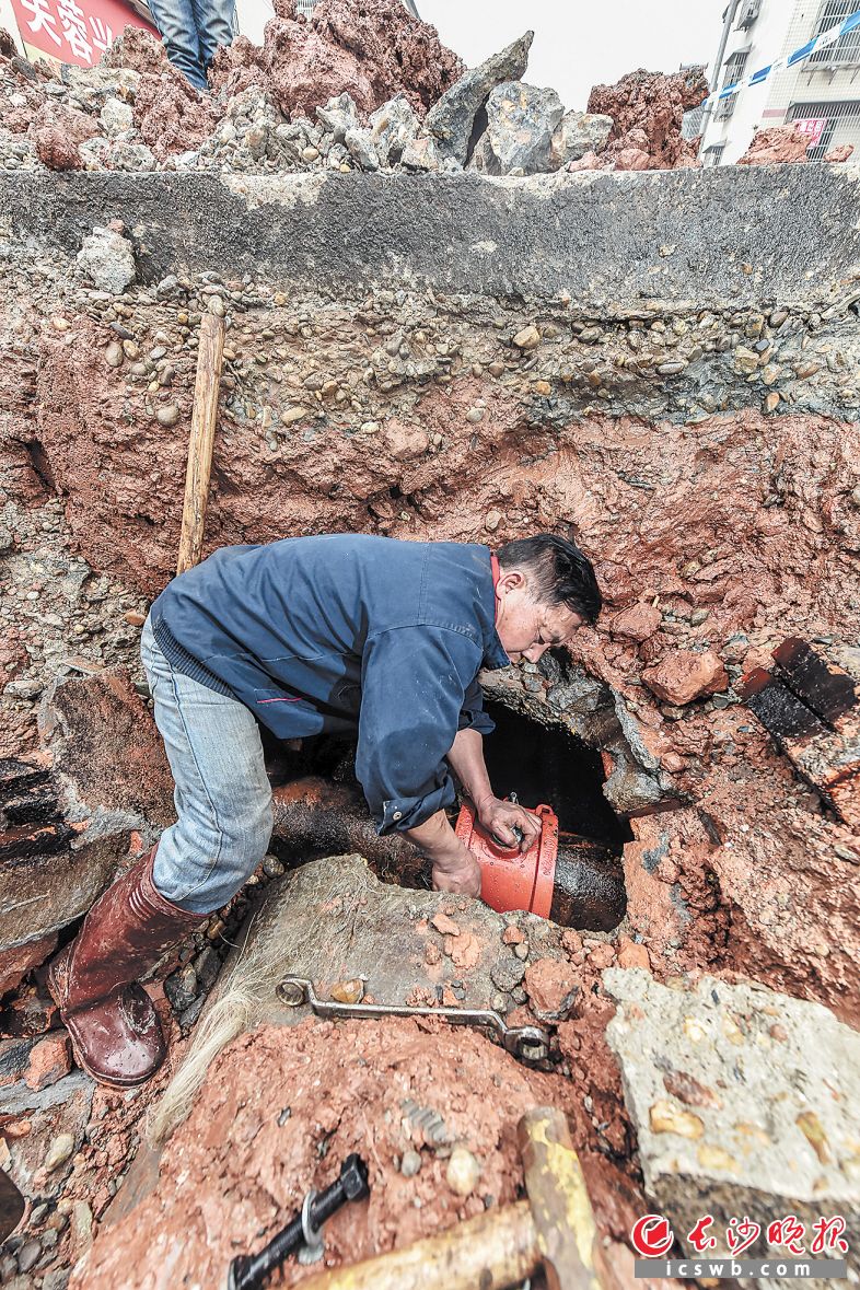 　　↑雨花区一居民安置区地下水管抢修现场，施工人员正冒着严寒抢修漏水的管道。陈飞 摄