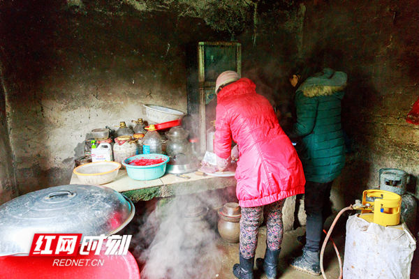 邻里的家庭主厨正围着灶台做年猪肉，准备“杀猪饭”供大家分享。