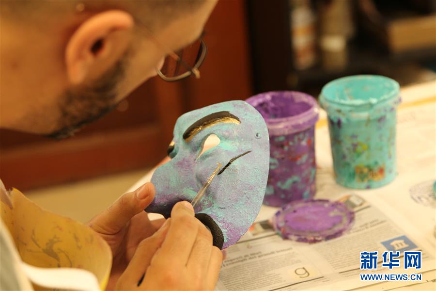 2月16日，在意大利威尼斯，一位游客在面具工坊绘制自己的威尼斯面具。 一年一度的威尼斯狂欢节正在意大利北部水城威尼斯举行，大街小巷挤满了着华丽服饰、戴精美面具的狂欢者，人们尽情享受节日的欢乐气氛。面具是威尼斯狂欢节的最大特色，也最令游客感兴趣。 新华社发（黄万晴 摄）