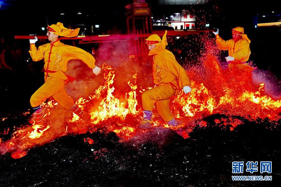 2月20日，在莆田市城厢区筱塘社区举行的“摆棕轿跳火”活动上，表演者跳过燃烧的火堆。 “摆棕轿跳火”是福建莆田元宵节前后最热闹的传统民俗活动。表演者抬着用棕料做成的“轿子”，随着时紧时缓的锣鼓声，一次又一次地跳过熊熊燃烧的火堆，围观的人群也呐喊助兴，寄托避灾、祈福等美好愿望。 新华社记者 张国俊 摄