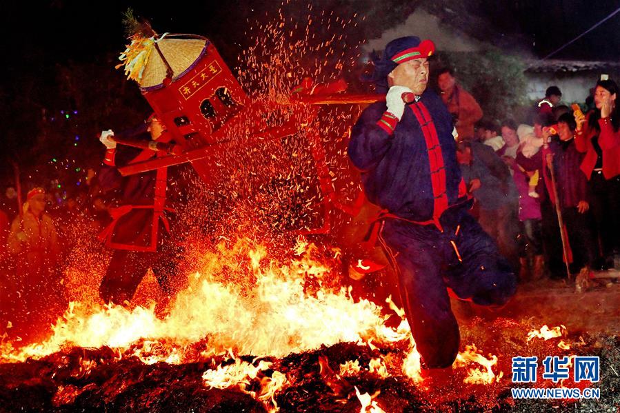 2月20日，在莆田市城厢区筱塘社区举行的“摆棕轿跳火”活动上，表演者跳过燃烧的火堆。 “摆棕轿跳火”是福建莆田元宵节前后最热闹的传统民俗活动。表演者抬着用棕料做成的“轿子”，随着时紧时缓的锣鼓声，一次又一次地跳过熊熊燃烧的火堆，围观的人群也呐喊助兴，寄托避灾、祈福等美好愿望。 新华社记者 张国俊 摄