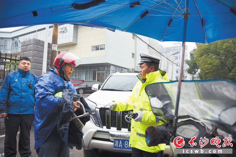 　　在德智园学生公寓门口，岳麓交警大队四中队民警对一辆违规载客且加装伞具的电动车驾驶人进行查处。                                                 长沙晚报全媒体记者 刘琦 摄