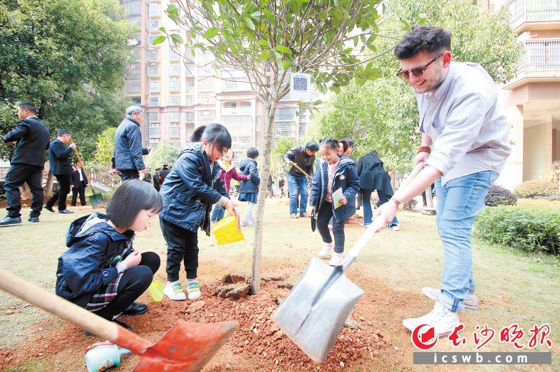 　　昨日，雨花区圭塘街道的百余居民参加植树护绿，洋义工和孩子们一起种下“友谊树”。  长沙晚报全媒体记者  陈飞  摄