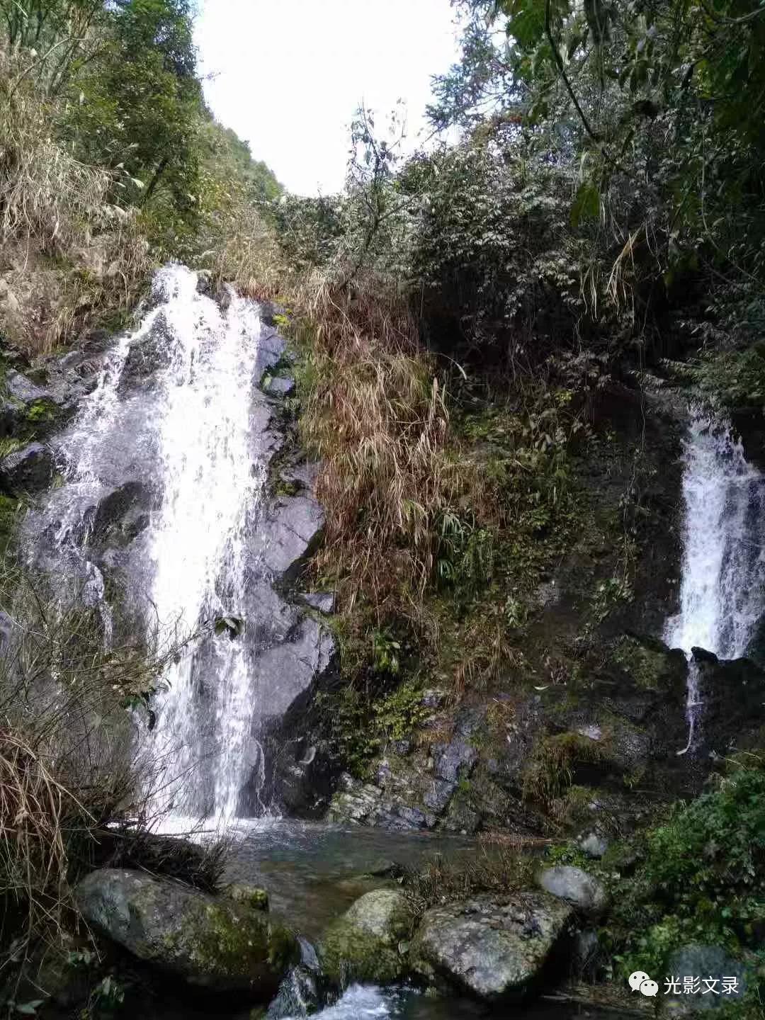 老洞坑山上还有一块宝地叫两扇岩，我们缓行慢步一路游览朝那方向走去，走了四十多分钟就到了两扇岩景点，这里更是十分醒目，举头仰望时，那壮观的景象使我血液沸腾，整座石峰就像在雾里飘着一样。拔地千尺，如利剑插入云霄，一扇巨崖直立，另一扇切断其上，像刀削斧凿，势如苍龙昂首，石峰顶上时有云遮雾绕，云来石更佳，云去石如画。雄奇诡险，峭壁生辉，是古往今来令人赞叹不已的绝景，吸引着来往游客的脚步、撩拨着游览者的眼睛。有多少人的情、多少人的魂附驻于岩倾注于峰。古诗曰：“会当石绝顶，一览众山矮，只有天在上，更无峰与齐。举头红日近，回首白云低”。巍巍的石峰直插蓝天，高大无比。