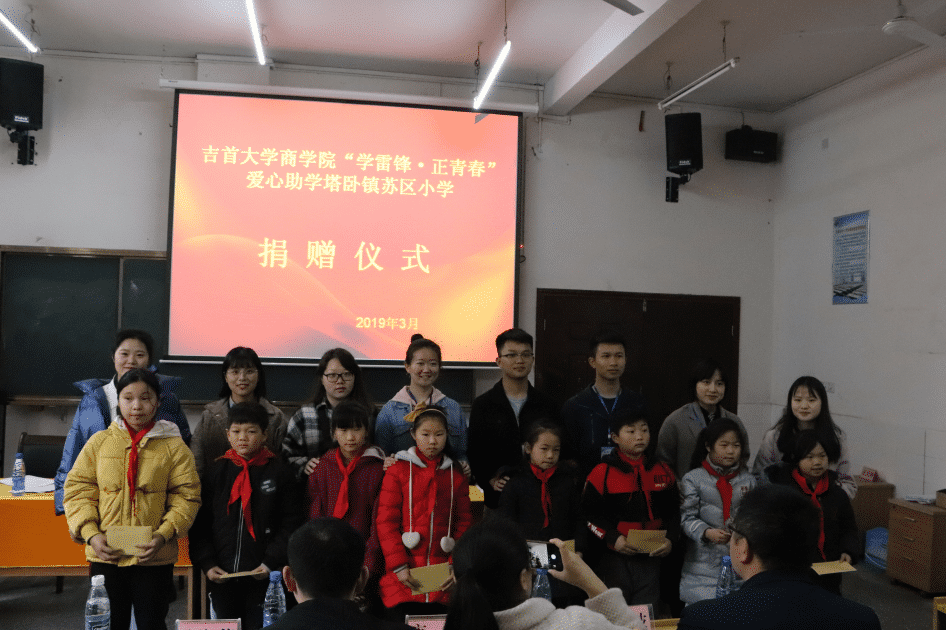 图为助学金发放环节爱心志愿者与塔卧苏区小学生合影.png