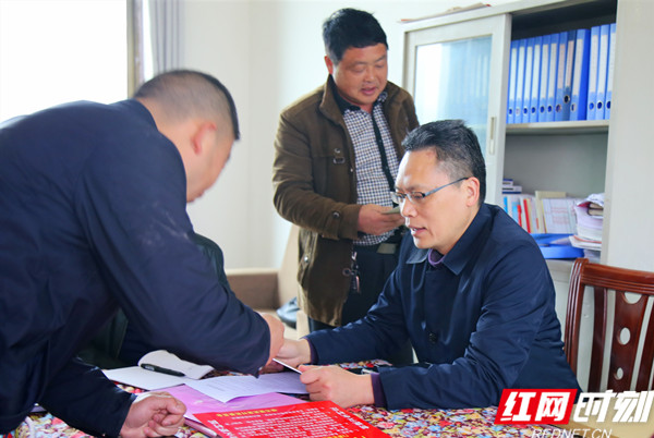 1图为市民政局党组书记、局长陈伟志（右一）查看芙蓉村扫黑除恶工作台账资料.jpg