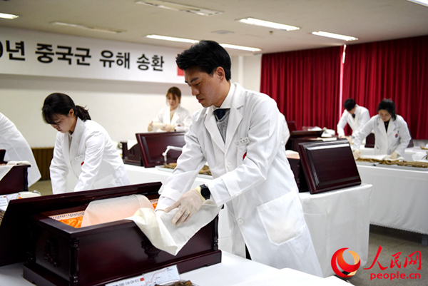 韩方工作人员装殓遗骸。夏雪摄