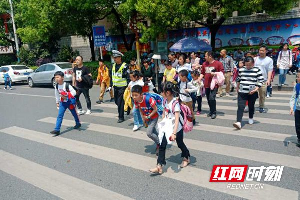 交警小学门口执勤 确保学生安全上下学