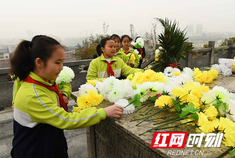 怀化市鹤翔学校全体师生向市烈士陵园烈士敬献小白花。