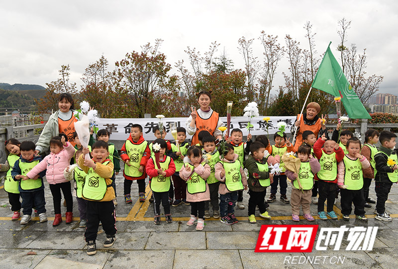 怀化博苑幼儿园幼师讲革命故事后带领儿童向革命烈士献花。