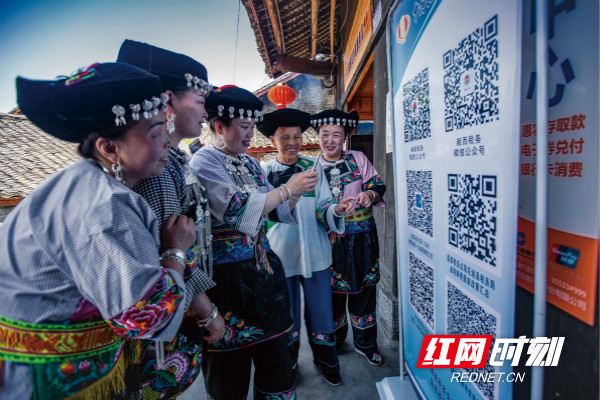 图为 湘西十八洞村民在便民办税服务点扫描“优惠政策二维码”_meitu_1.jpg