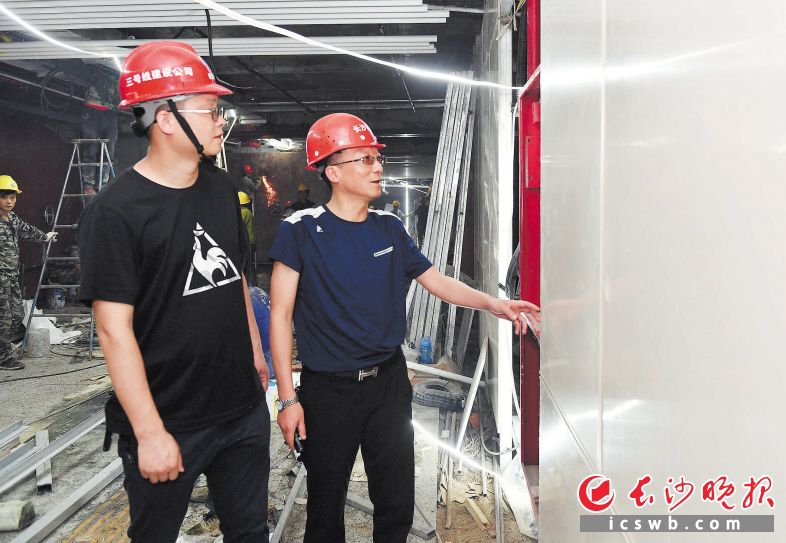 　　钟可（右）和同事在建设中的长沙地铁4号线阜埠河站查看工程建设质量。长沙晚报全媒体记者 周柏平 摄