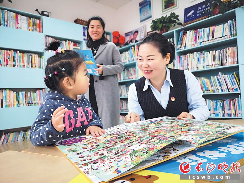 　　在江湾社区阅读室，袁灿（右）与前来进行亲子阅读的孩子和家长交流。 长沙晚报全媒体记者 小刘军 摄