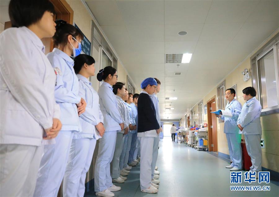 5月9日，湖南省衡阳市南华大学附属第一医院护士康石墙（右二）在给白班的护理工作人员交班。