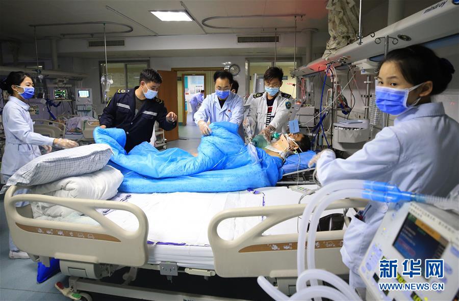 5月9日，湖南省衡阳市南华大学附属第一医院护士康石墙（左三）在接收转院过来的危重患者。