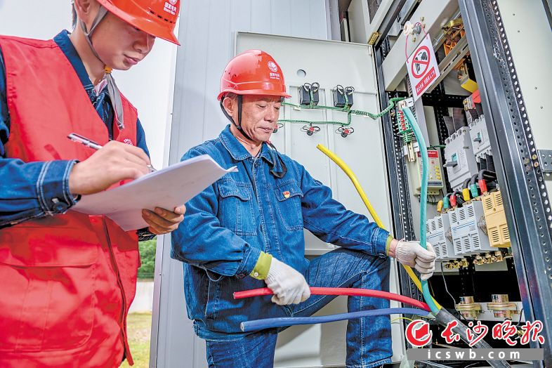 　　国网长沙县供电公司    梨供电所所长张立志(右)在指导员工进行实际操作。　　长沙晚报全媒体记者 陈飞 摄