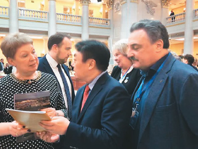 　2019年3月，吴昊（中）在参加俄罗斯圣彼得堡国际教育论坛时，向俄罗斯教科部部长瓦西里耶娃女士（左）介绍自己办的俄文杂志。