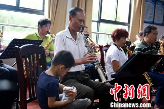 乐器班的一名学员带着孩子来上课。朱柳融 摄