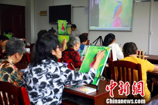 水粉画课上,学员跟着老师一起画画。朱柳融 摄