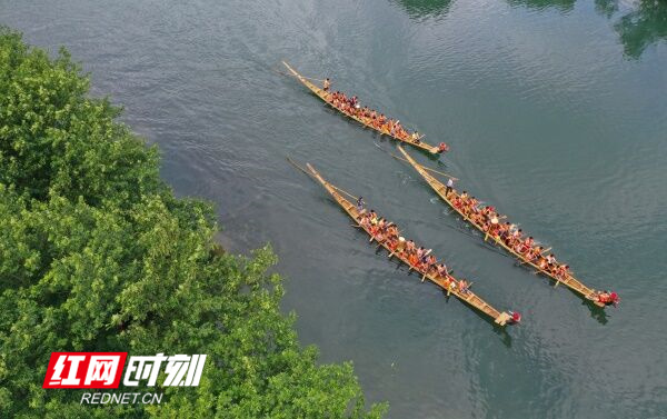 道县洑水河梅花贵头段，村民在岸青水碧的河面上划龙舟。