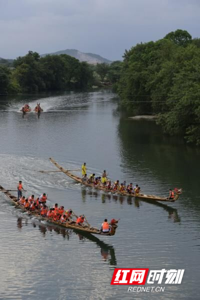 道县洑水河梅花贵头段，村民在岸青水碧的河面上划龙舟。