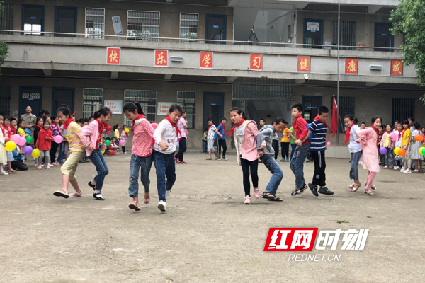 新民小学孩子们在操场开展抱团竞走比赛。