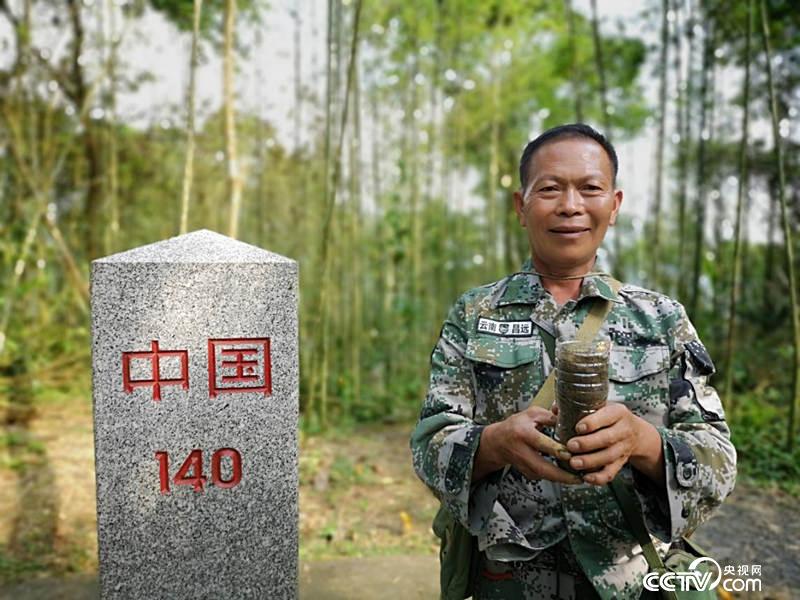 杨天才在界碑前取了一捧土，给记者带去北京。（何川 摄）