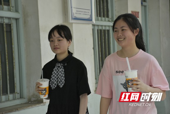 刚吃完晚餐的两名考生正拿着奶茶准备进教室。