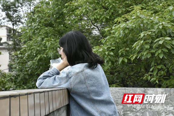 独自看着校外车流，是她考前最后的放松。
