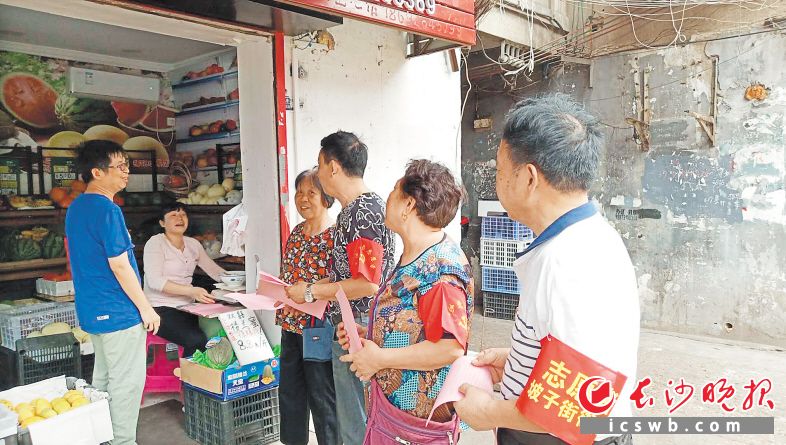 　　社区工作人员、党员志愿者上门，向商户发倡议书。长沙晚报通讯员 王国光 摄
