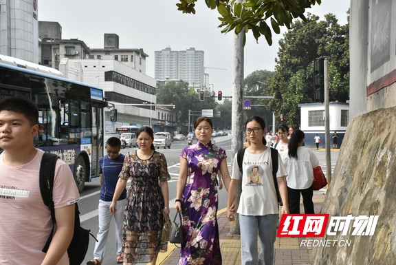 红网时刻益阳6月7日讯（实习记者 刘志雄 记者 钟浩）今日高考，不少妈妈身着旗袍为孩子送考，寓意“旗开得胜”。图为7：57，穿着紫色旗袍的家长正陪考生走到一中围墙外。