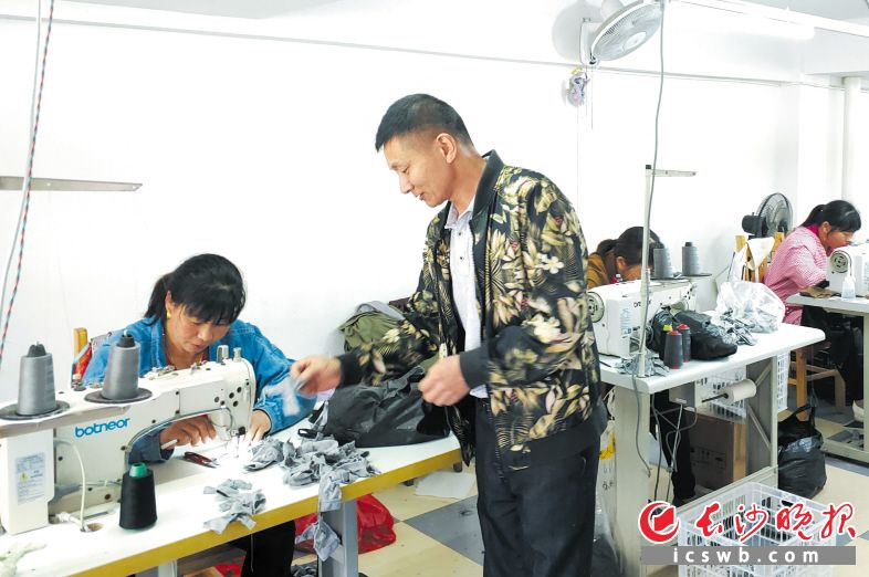 　　姜果明（右）在指导工人生产。