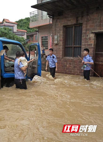 过膝盖的洪水中民警转移群众.jpg