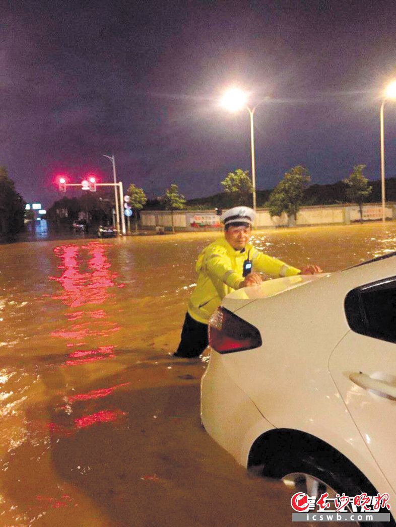 　　21日，长沙突遇暴雨，交警坚守岗位，帮助市民推车。长沙交警供图