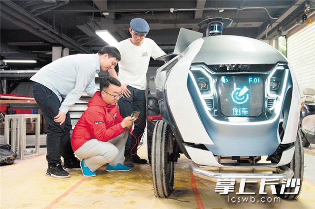 日前，长沙智能机器人研究院田野智能科技有限公司内，研究人员正在对首款纯电动智能行驶拖拉机进行调试。