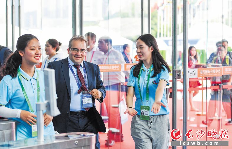 6月27日下午，来自长沙理工大学的谭琦（右一）和湖南外贸职业学院的江雨微（左一）在热情地为外籍参展商服务。