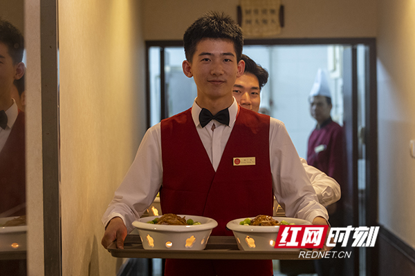准备为晚宴上菜的酒店服务员微笑着为每位来宾服务。